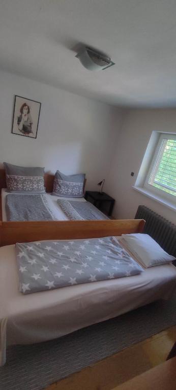 two beds in a room with a window at Apartmán Radim in Vratimov
