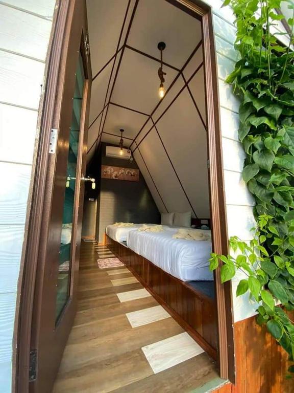 a room with a bed and a hallway with a mirror at Hosanna village in Semporna