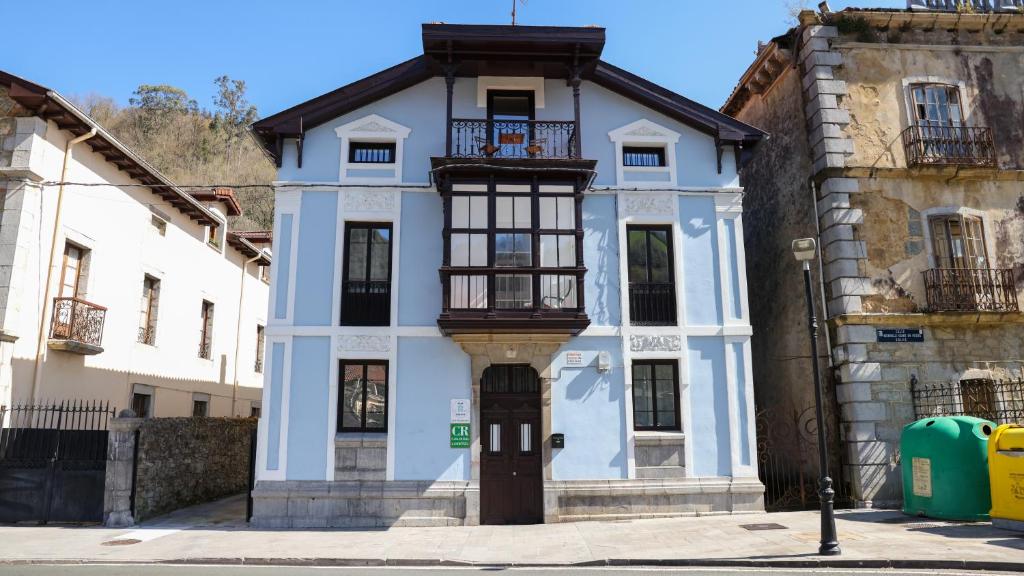 a blue and white house with a balcony at Casa Vizcaya, Casa rural para grupos de hasta 20 personas en Lanestosa, ideal para reuniones y celebraciones tranquilas in Lanestosa
