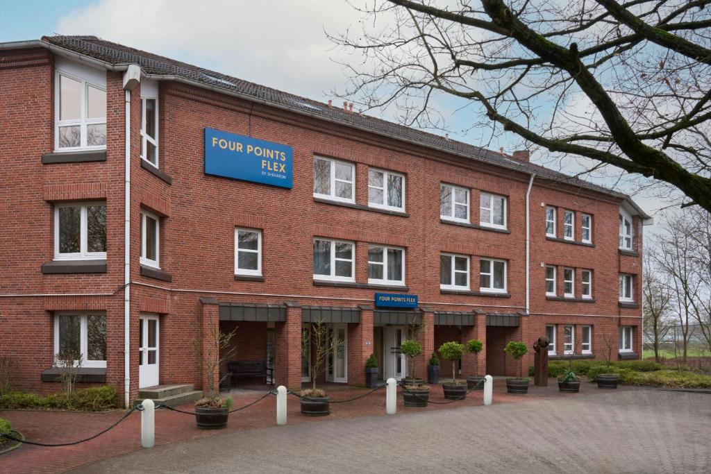 a red brick building with a blue sign on it at Four Points Flex by Sheraton Kiel in Kiel