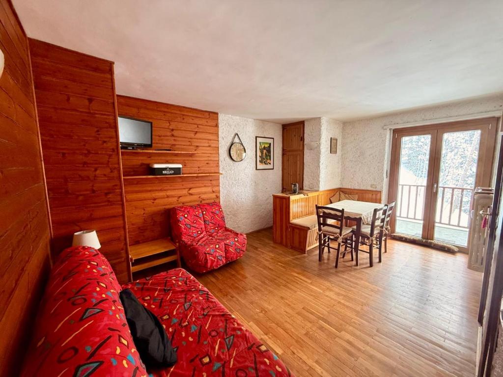 ein Wohnzimmer mit einem Bett und einem Tisch mit Stühlen in der Unterkunft Piccolo Bric in Ghigo