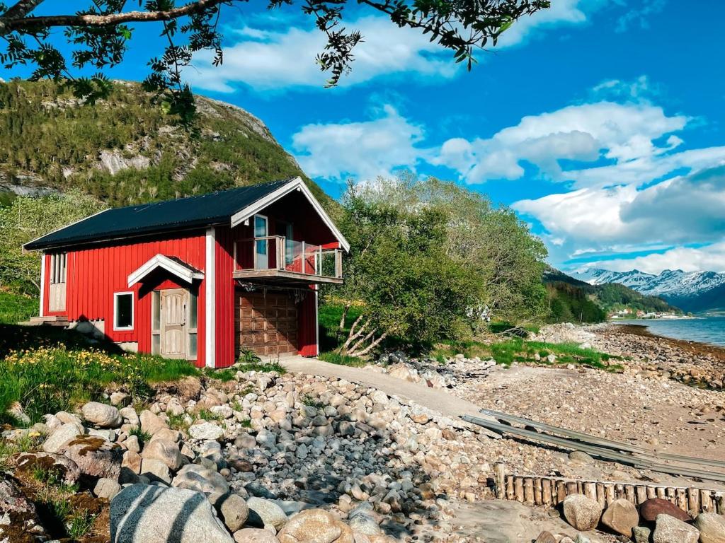 a red house on the side of a mountain at Unique boathouse with a spectacular view in Oldra