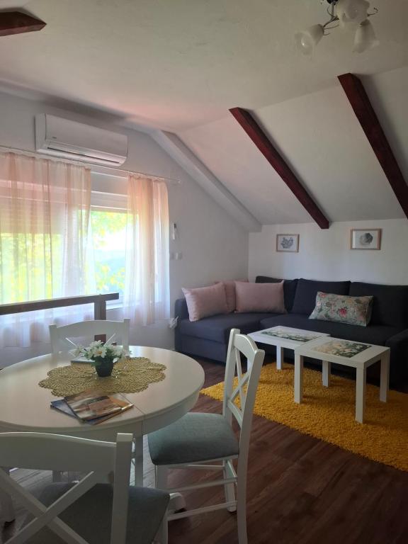 a living room with a table and a blue couch at Agroturizam Na Malenom brijegu IVANČICA in Veliki Grđevac