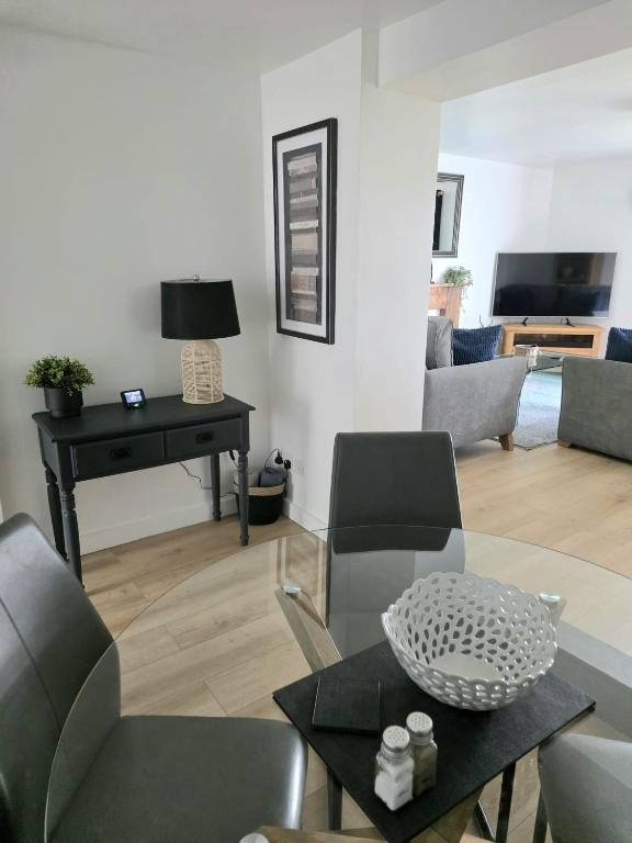 a living room with a table and chairs and a piano at 12 Ivy Cottage in St Ives