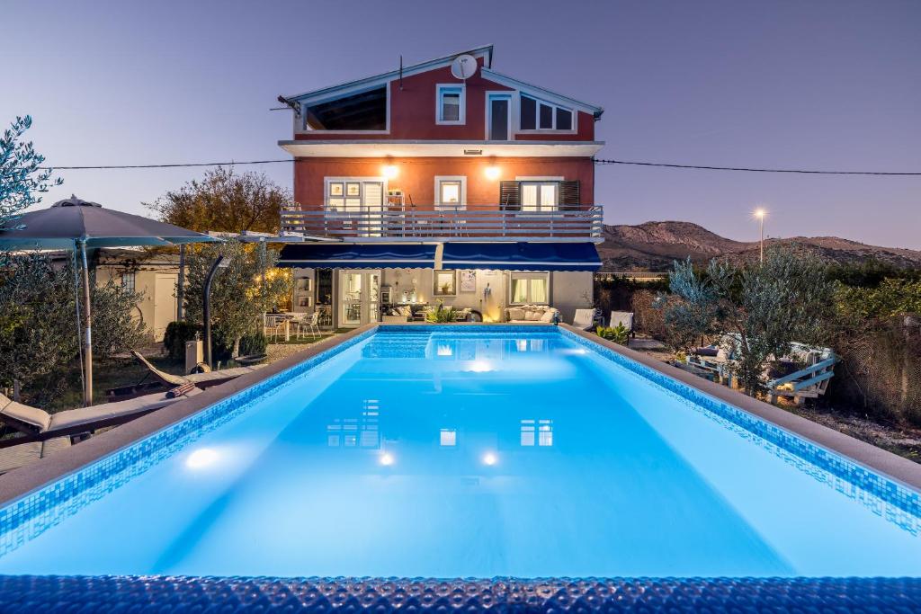a house with a swimming pool in front of a house at Holiday house Goran, Opuzen in Opuzen