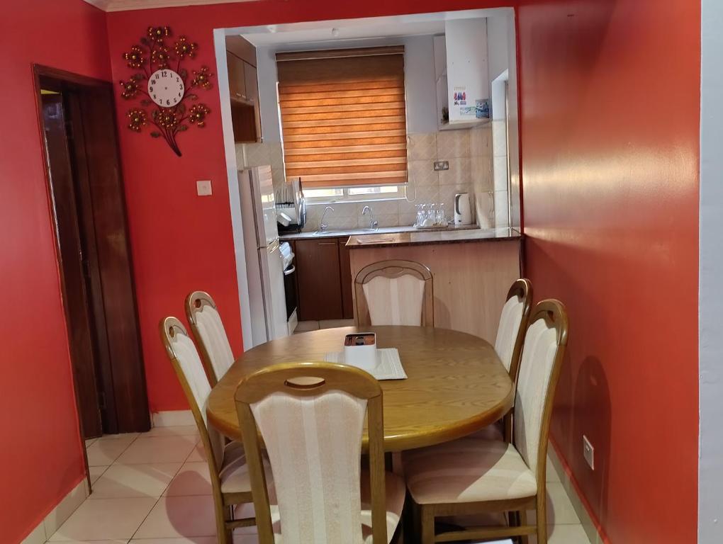 a small kitchen with a wooden table and chairs at Greatwall golden stay in Machakos
