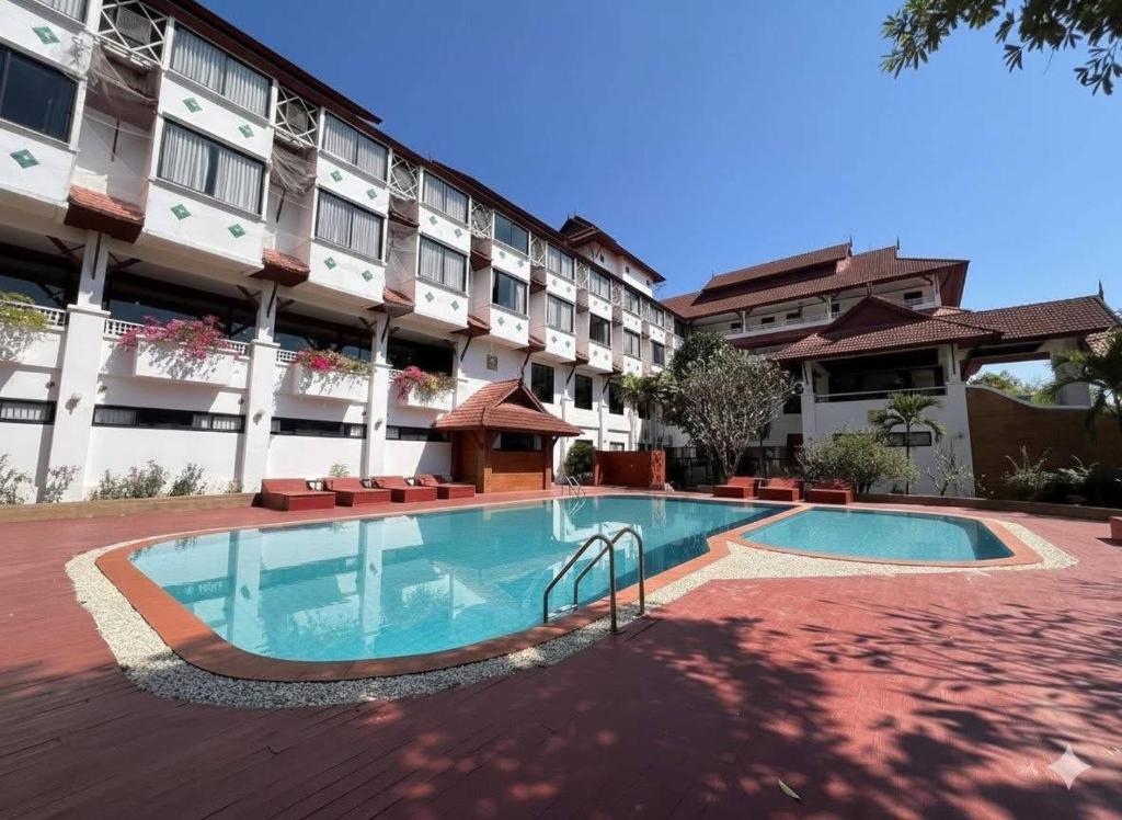 a swimming pool in front of a building at Lanna Oriental Maejo in Chiang Mai