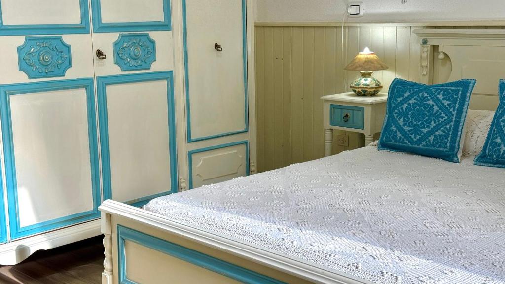 a bedroom with a bed with blue and white at Casa vacanze Nuraghe Orosei in Orosei