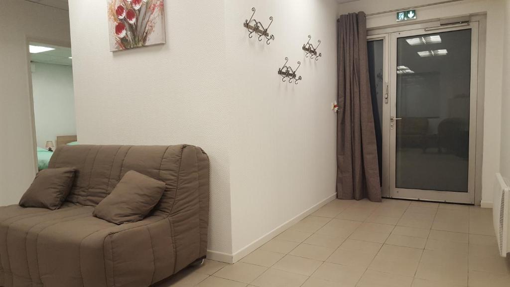 a couch sitting in a living room next to a door at Gite grand format in Colmar