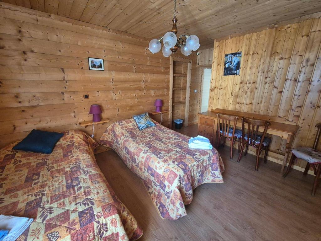 a bedroom with two beds and a table in a cabin at Les Touristes in Abondance