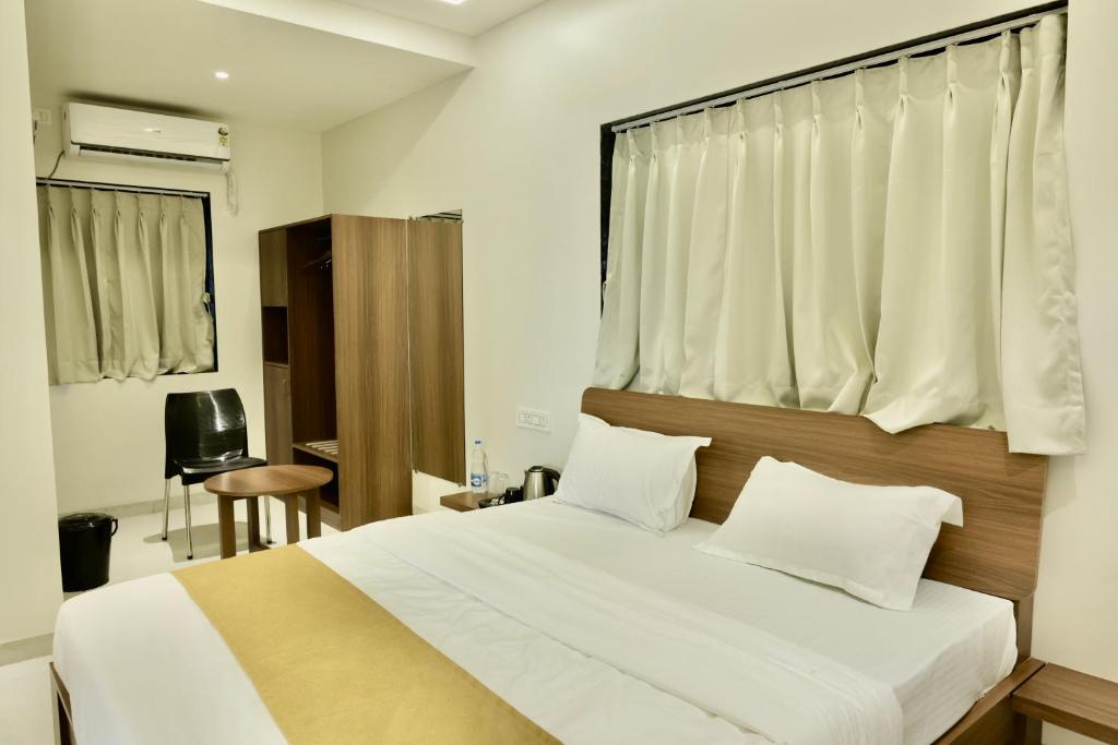 a bedroom with a large white bed with a window at SeaYou Stay in Daman