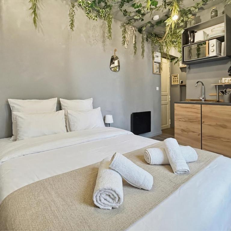 a bedroom with a large white bed with towels on it at Petit nid douillet, à deux pas des commodités in Neuilly-Plaisance