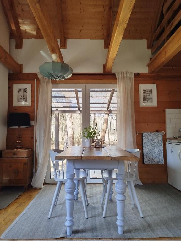 ein Esszimmer mit einem Tisch und einem Fenster in der Unterkunft Ulęgałki Roztocze in AdamÃ³w