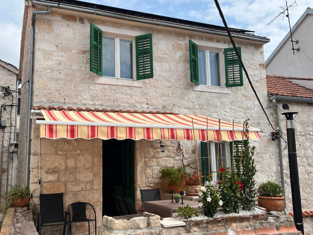 a building with awning on the front of it at Apartment Dalmatera in Rogoznica
