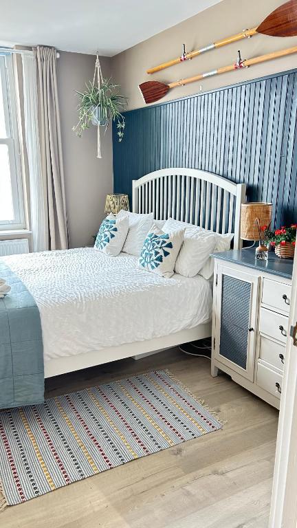 a bedroom with a white bed and a desk at Little Gem in Swanage