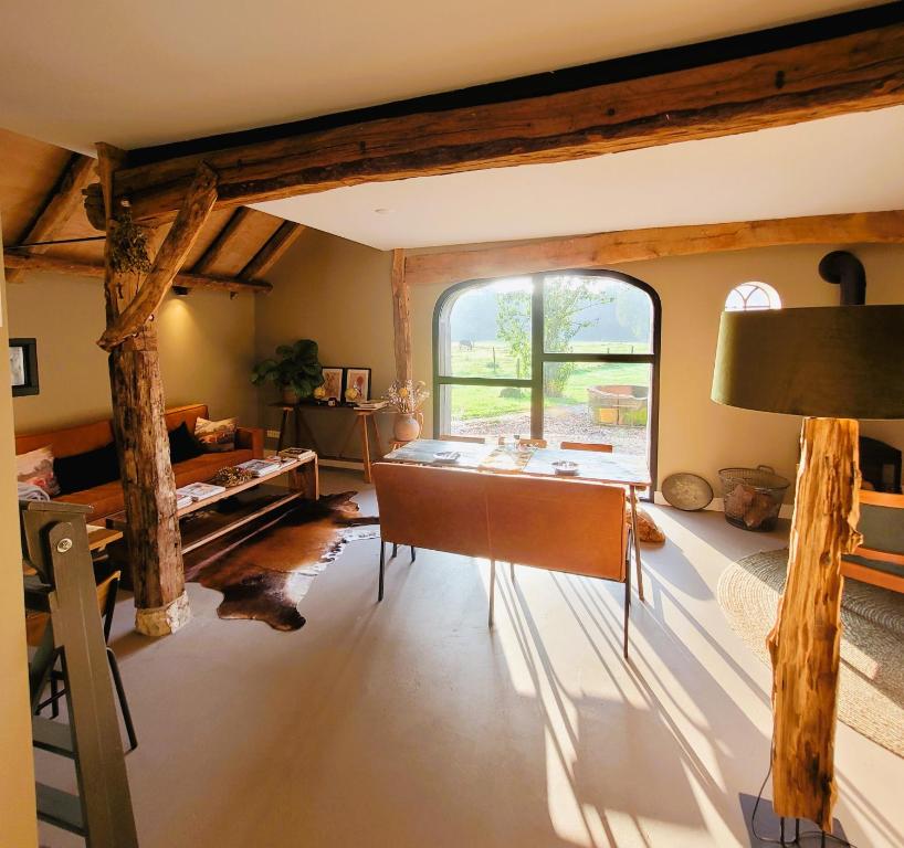 a living room with a table and a large window at 't Buitenverblijf Erve Punte in Losser