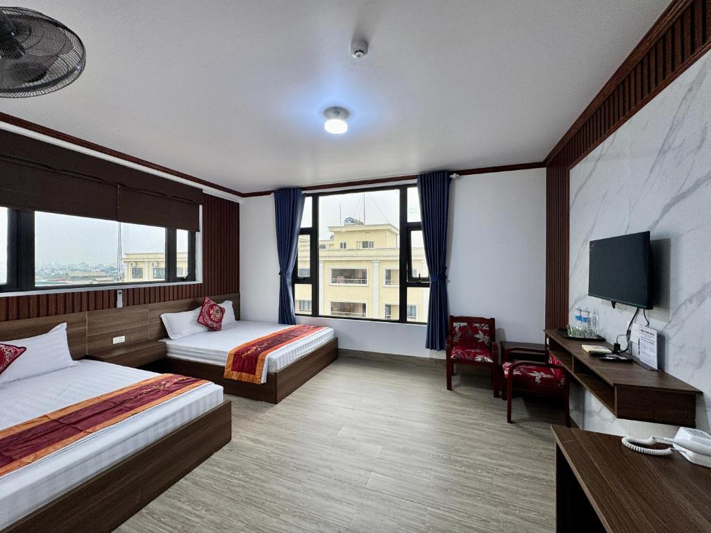 a hotel room with two beds and a large window at Xuan Thanh Hotel in Thanh Hóa