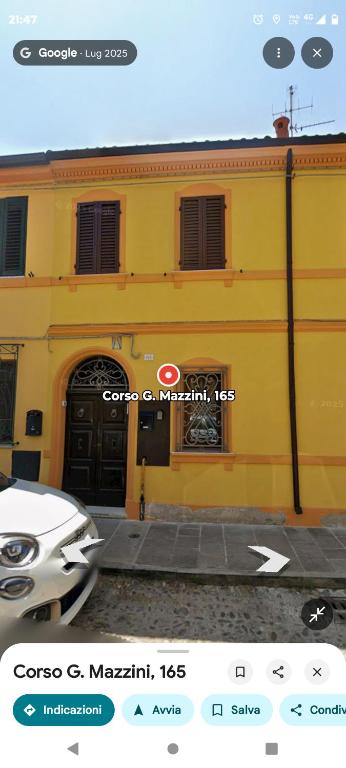 a yellow building with a car parked in front of it at Casa Cappuccini in Comacchio