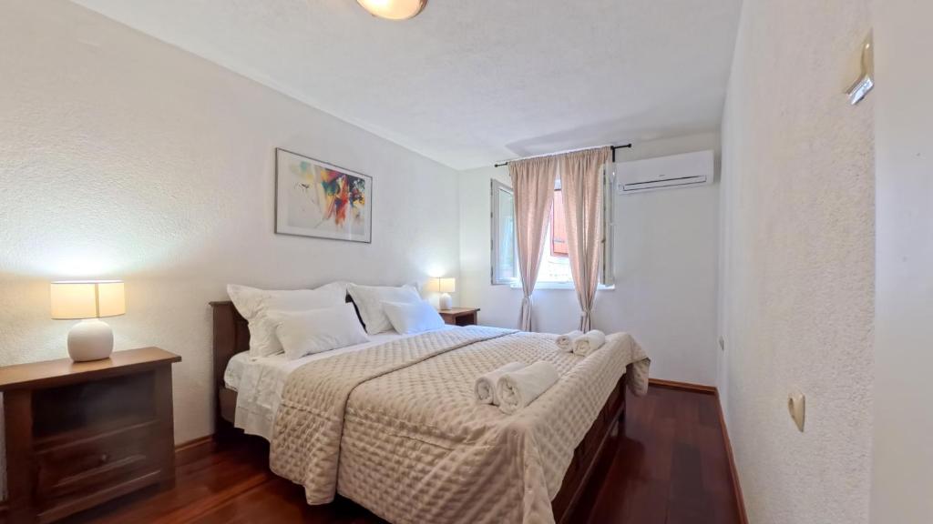 a bedroom with a bed with a white bedspread at Old Town Stay by Ivo in Trogir
