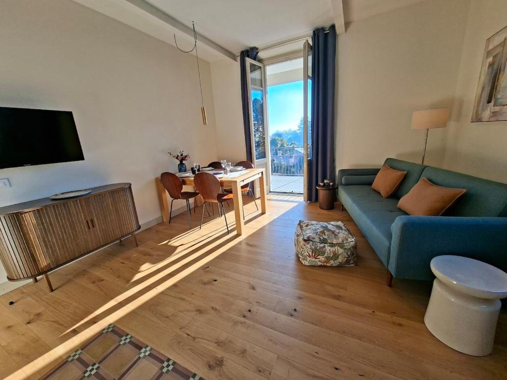 a living room with a blue couch and a table at Villa Grappoli Apt MAGGIORE with lake view in Lesa