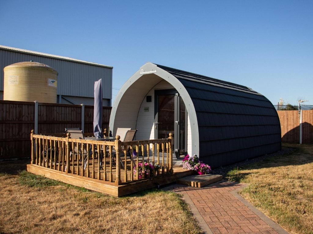 a black and white building with a porch and a house at Skylark - Pod in Northrepps