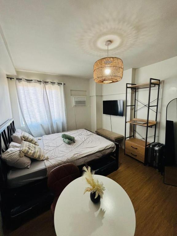 a living room with a bed and a table at Urban Oasis Symphony Pool in Cebu City