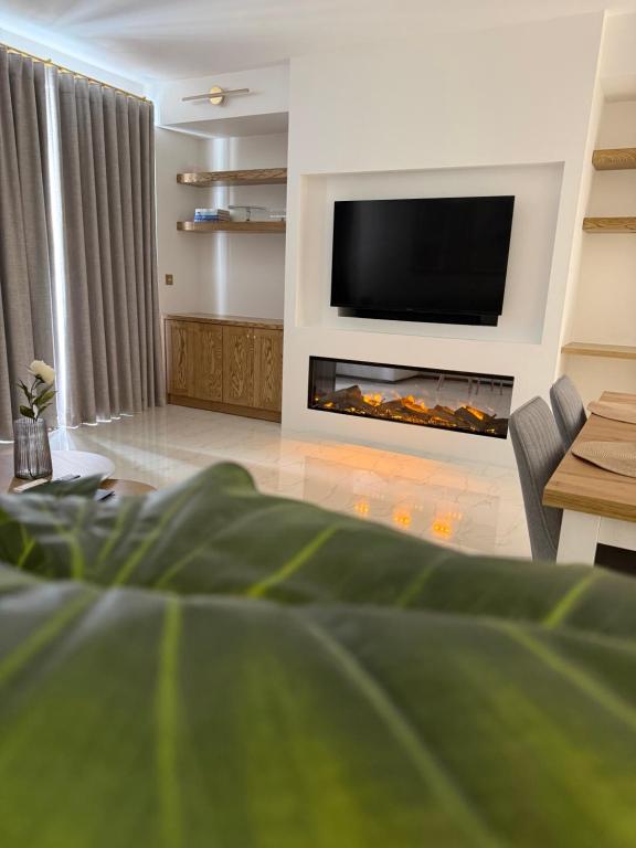 a living room with a fireplace and a tv at Perlina Naxxar in Naxxar