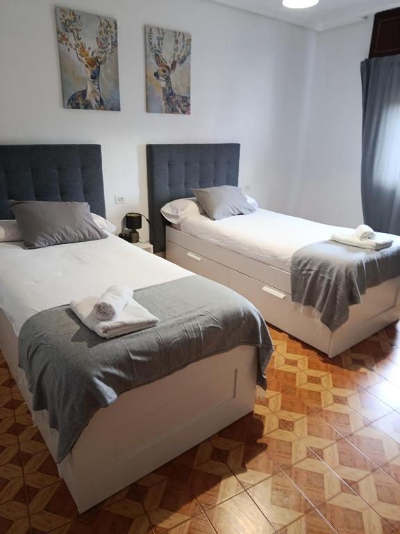 two beds sitting next to each other in a bedroom at A Ribeira in Fene