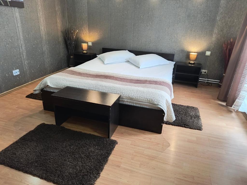 a bedroom with a large bed with two rugs at Casa Mais Brașov Guesthouse with Free Parking in Braşov