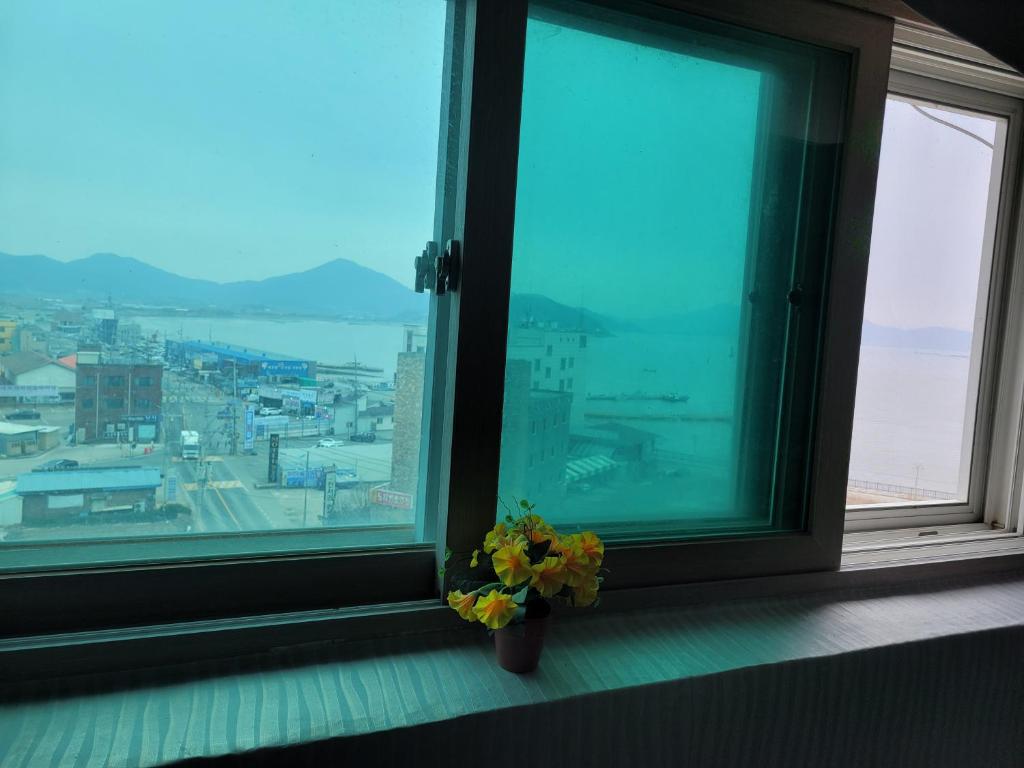a vase of flowers sitting on a window sill at 힐하우스 in Chŏngp'op'ogu