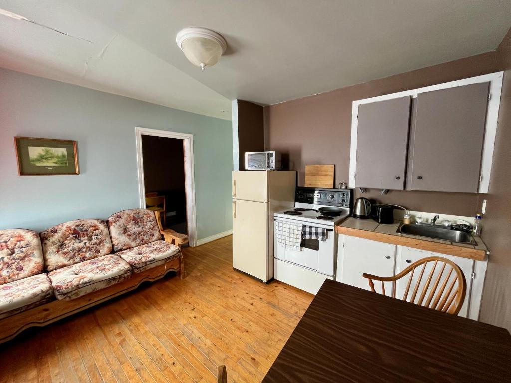 a living room with a couch and a kitchen at Bennett Lodge in Daniels Harbour