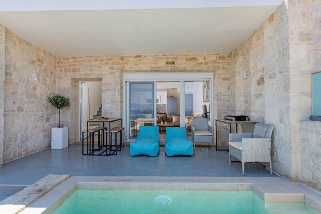 a room with a swimming pool and a living room at MyPanormo Suites - Philip in Panormos Rethymno