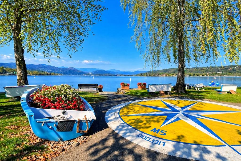 a boat filled with flowers sitting next to a lake at LaBohème Lake Maggiore Retreat with Private Beach in Dormelletto