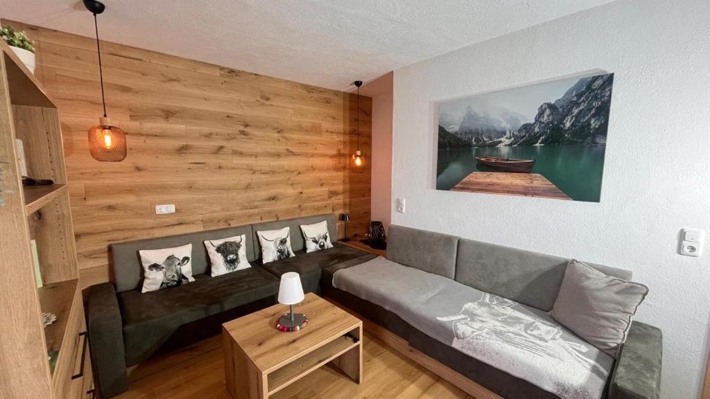 a living room with a couch and a wooden wall at Apfel-Stadl "Gala", Oberreute in Oberreute
