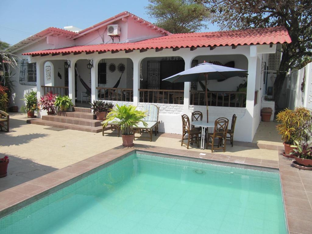 a house with a swimming pool in front of a house at Casa Playas in Playas