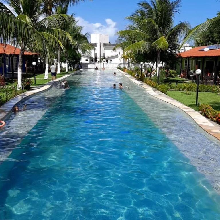 a pool at a resort with people in the water at Casa Bela in Itamaracá