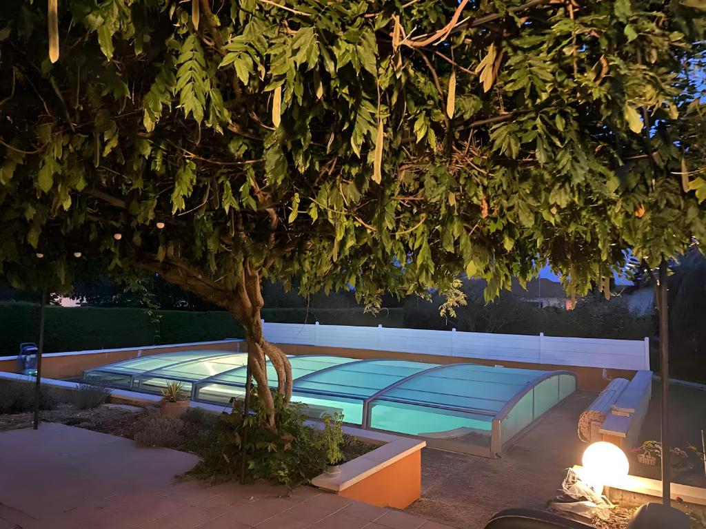 two beds under a tree in a courtyard at L'Esprit Cottage in La Tranclière