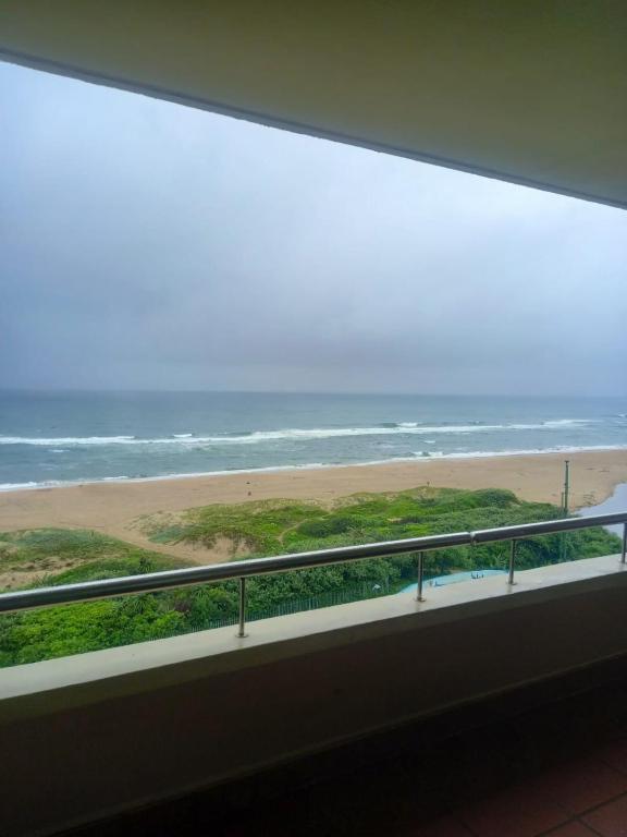 a view of the beach from a window at Lescalier 513 Luxury sea facing unit in Amanzimtoti