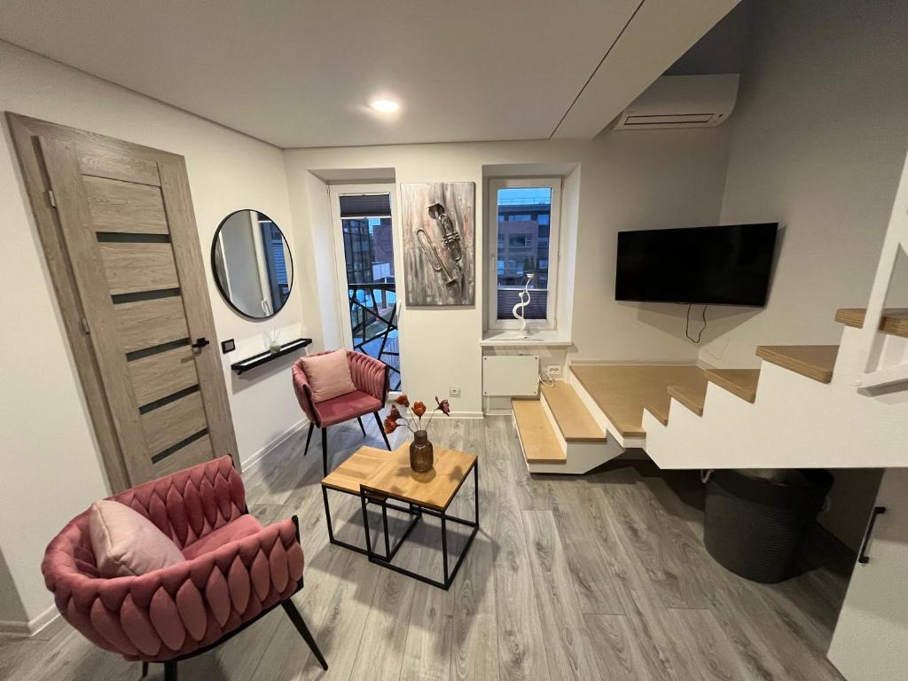 a living room with two chairs and a television at Apartments ,,Morena'' Melnragė in Melnragė
