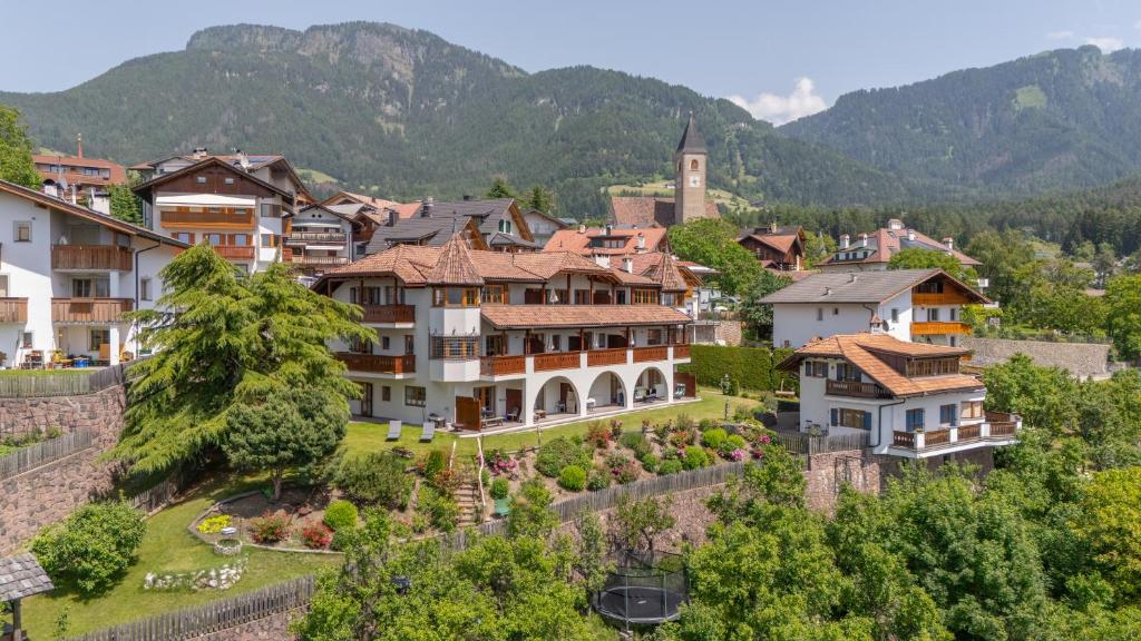 a village in the mountains with houses and trees at Residence Burghof in Siusi