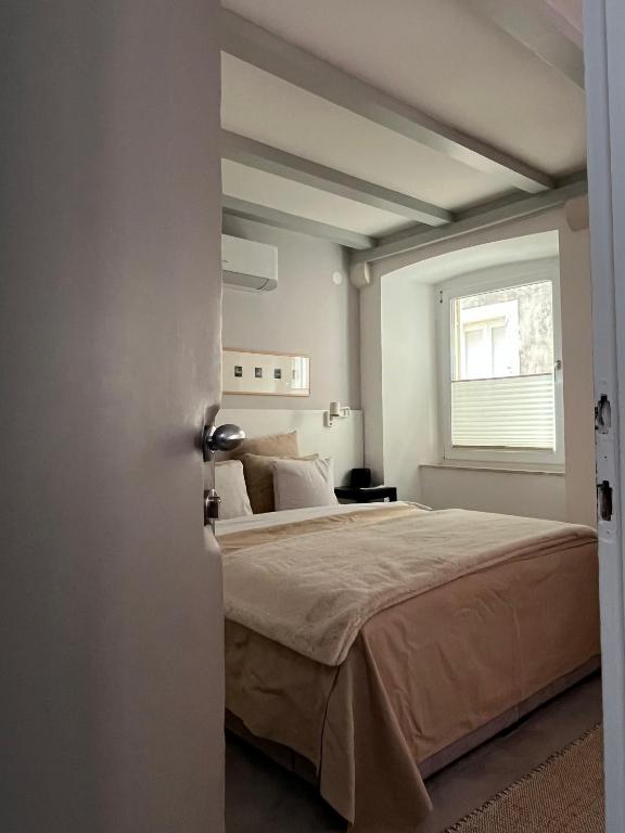 a bedroom with a large bed and a window at Cozy Old Town Interlude Apartment in Dubrovnik