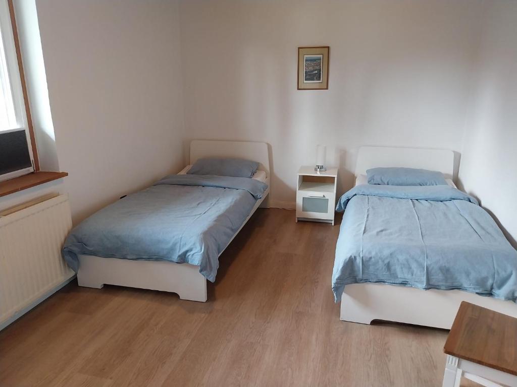 a bedroom with two beds and a wooden floor at FeWo beim Schmetterlings Park in Buchholz in der Nordheide