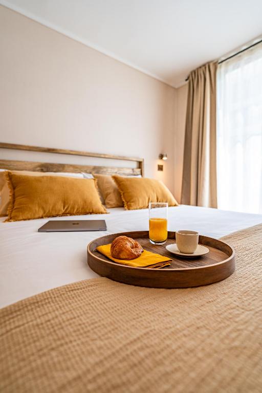 a tray with a drink and a plate of food on a bed at Nest Collection El Golf in Santiago