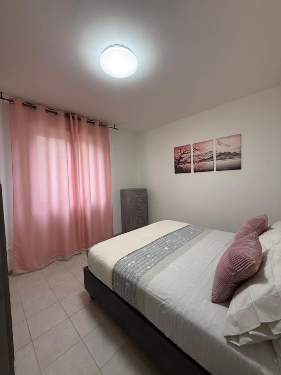 a bedroom with a large bed with pink curtains at Via Veneto in Loreto Aprutino