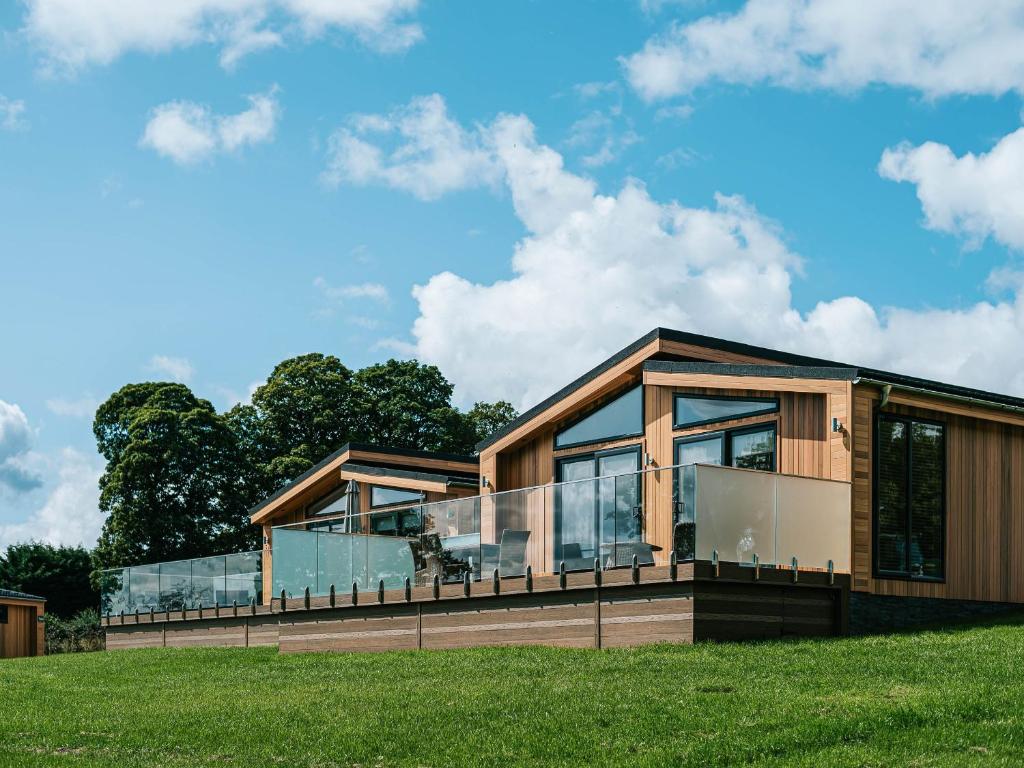 a house with glass windows on a green field at Rue - Uk51100 in Clitheroe
