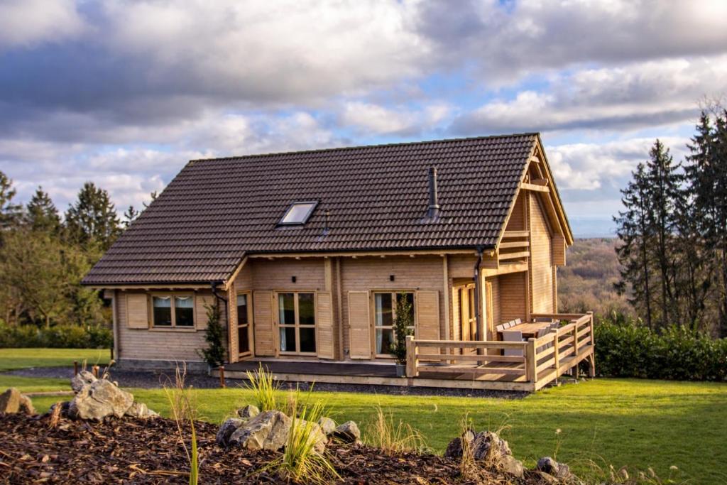 a small wooden house with a black roof at Valentina Lodge in Durbuy