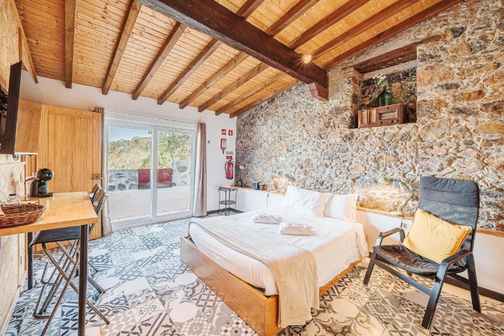a bedroom with a bed in a room with a stone wall at Villas de Cintra in Sintra