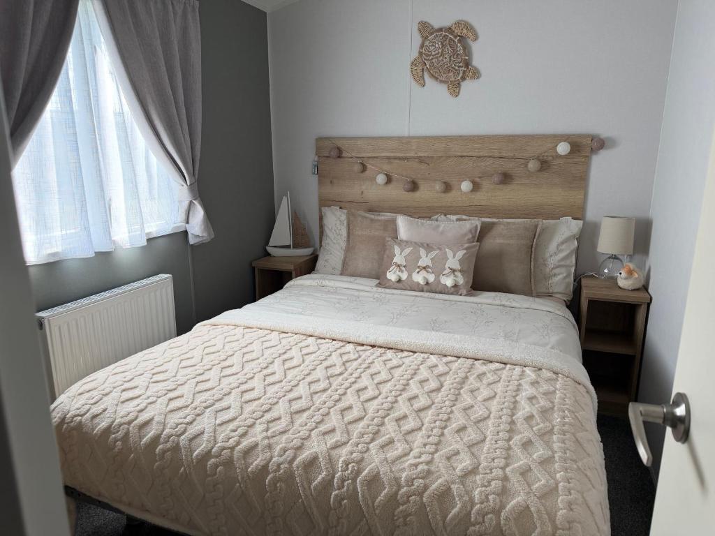 a bedroom with a large bed with a wooden headboard at Big Boss Caravan-Camber Sands,Sleep 8, Free Wi-Fi, Netflix, Parking in Camber