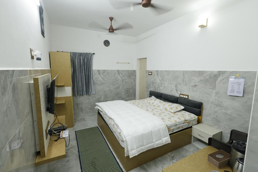 a bedroom with a bed and a tv in it at Sri Kalki Jamjam Resort in Erode
