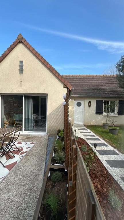 a house with a fence and a patio at Gîte du Cap Romain in Bernières-sur-Mer